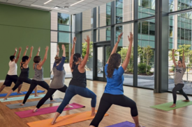 Participants standing in forward lunges, arm stretched up towards the ceiling Participants standing in forward lunges, arm stretched up towards the ceiling